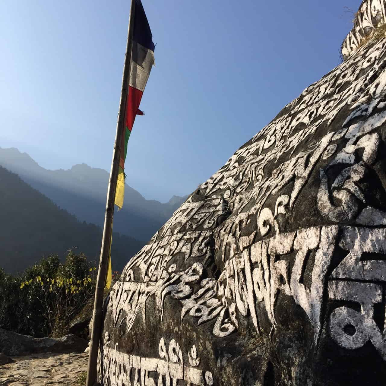 solitary prayer flag at sacred rock in khumbu region, nepal