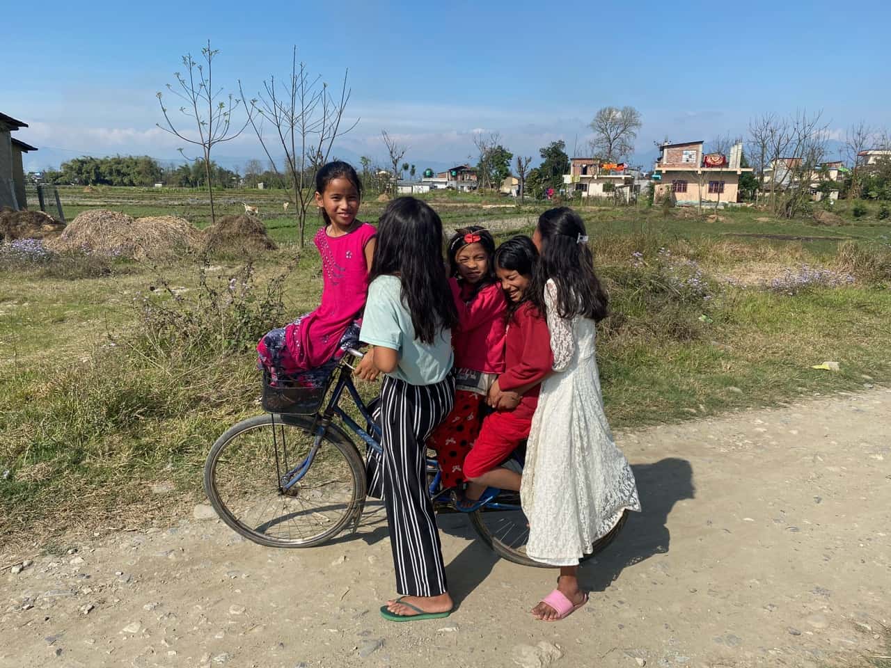 madi eco-village, local girls sharing a bicycle ride